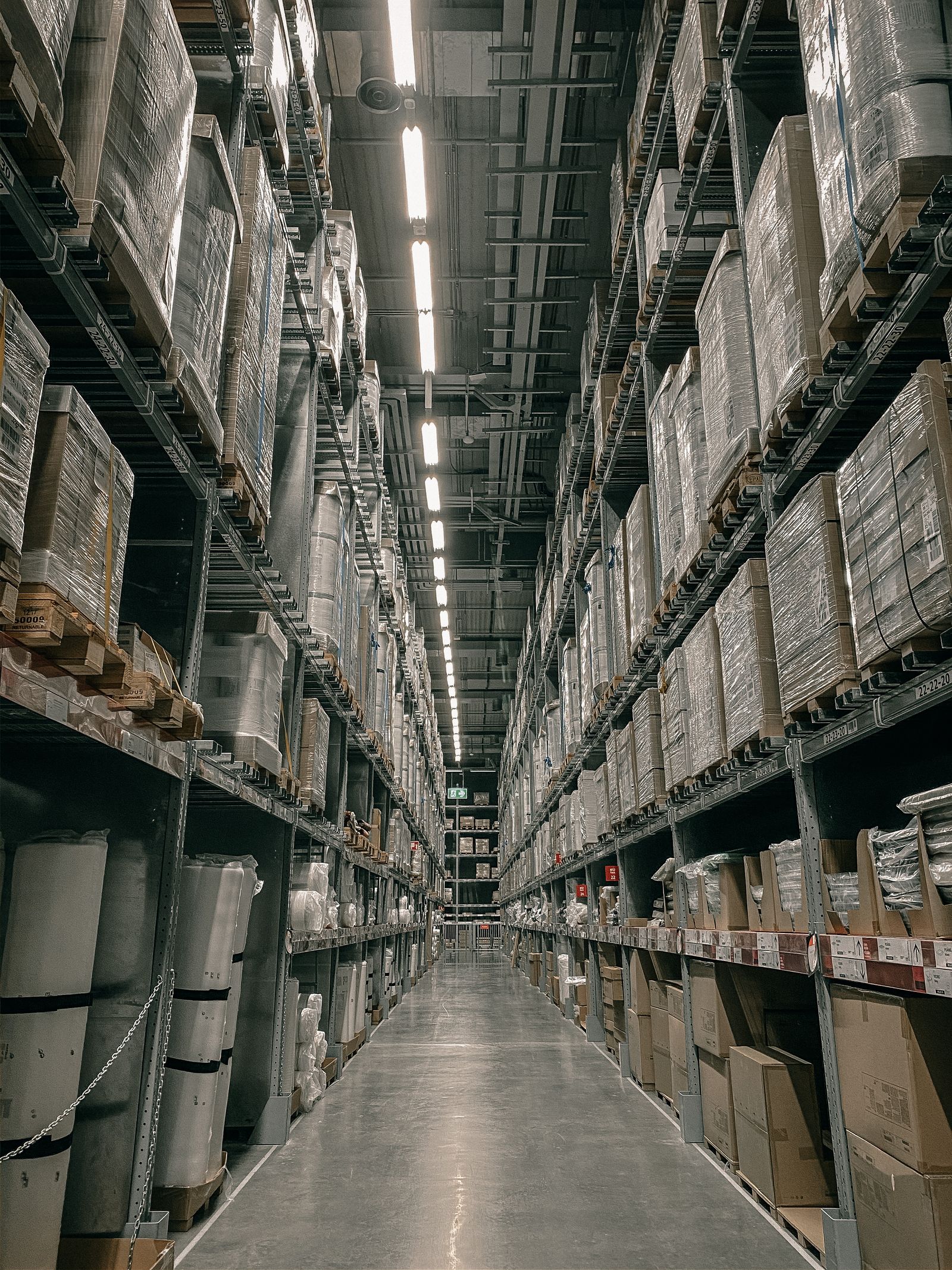 Tall warehouse aisle lined with palletized freight
